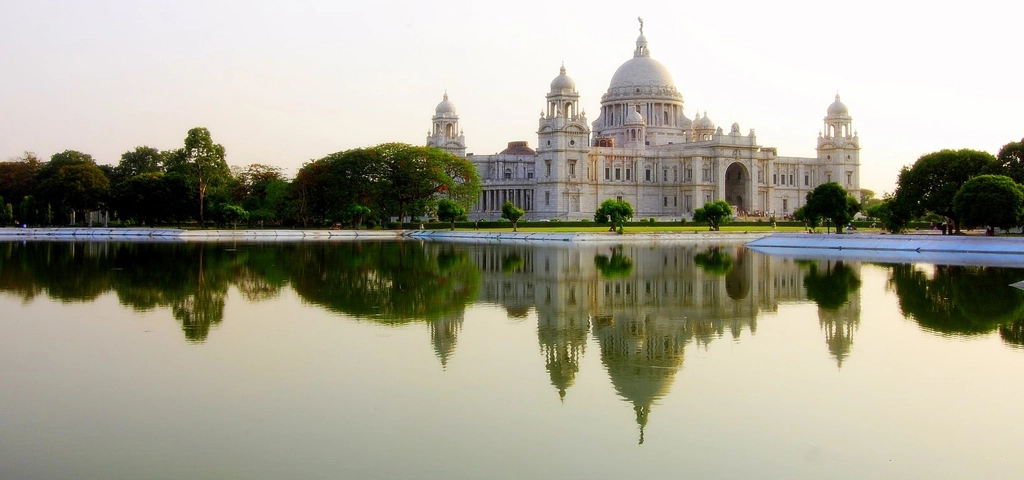 Victoria Memorial, grand white marble building reflected in water, popular with tour operators in Kolkata.