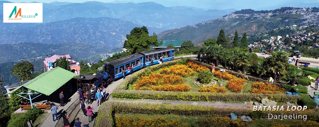 Batasia Loop in Darjeeling: toy train, vibrant garden, lush green hills. Gangtok Darjeeling Tour Package feature.